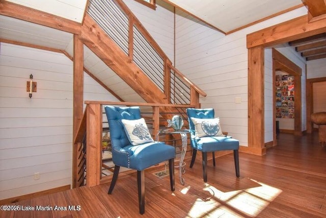 sitting room with hardwood / wood-style flooring and wooden walls