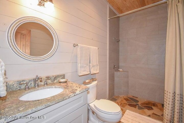 bathroom featuring a shower with curtain, wooden walls, vanity, and toilet