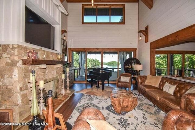 living room featuring a fireplace, wooden walls, and a high ceiling