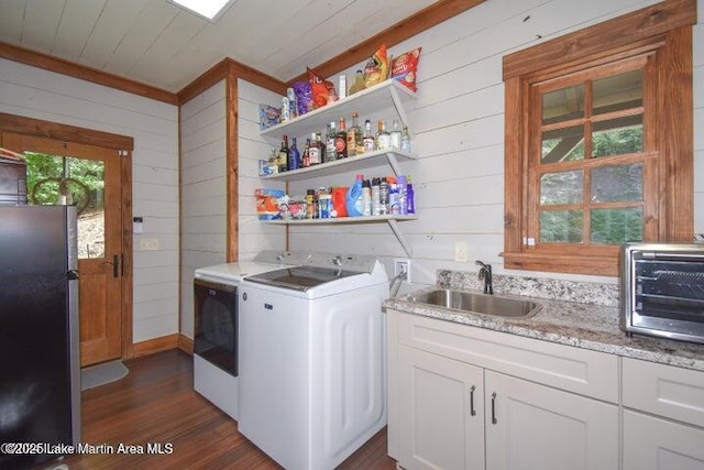 laundry area with wooden walls, sink, dark wood-type flooring, wooden ceiling, and washer and clothes dryer