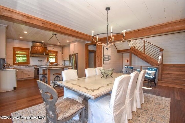 dining area with dark hardwood / wood-style flooring, a notable chandelier, and beam ceiling