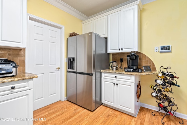 876 Ridge Rd, Dadeville, AL 36853 - kitchen featuring stainless steel fridge with ice dispenser, crown molding, tasteful backsplash, white cabinets, and light wood-style flooring