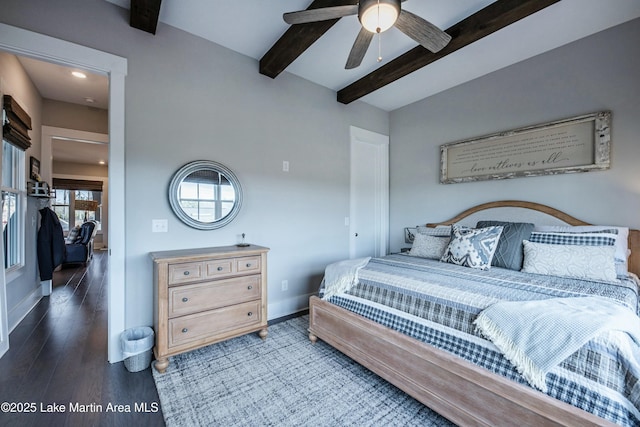 bedroom featuring ceiling fan, dark hardwood / wood-style floors, and beamed ceiling