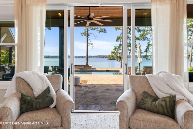 doorway featuring ceiling fan and a water view