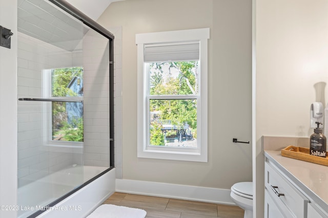 full bathroom with vanity, toilet, enclosed tub / shower combo, and a wealth of natural light