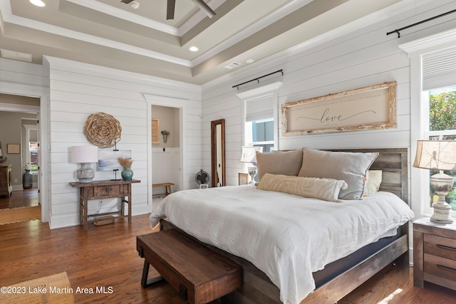 bedroom with a tray ceiling, ceiling fan, crown molding, and dark hardwood / wood-style floors