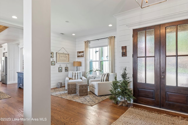 entrance foyer with wooden walls, french doors, crown molding, and dark hardwood / wood-style floors