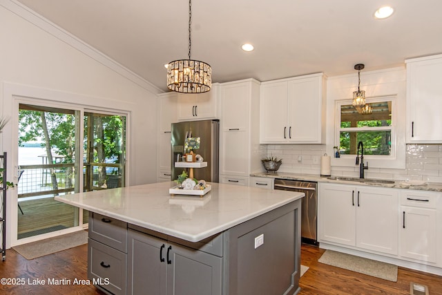 kitchen with stainless steel appliances, sink, pendant lighting, and white cabinets