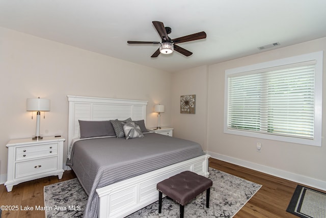 bedroom with dark hardwood / wood-style flooring and ceiling fan