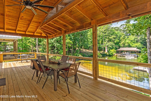 deck with a water view and ceiling fan