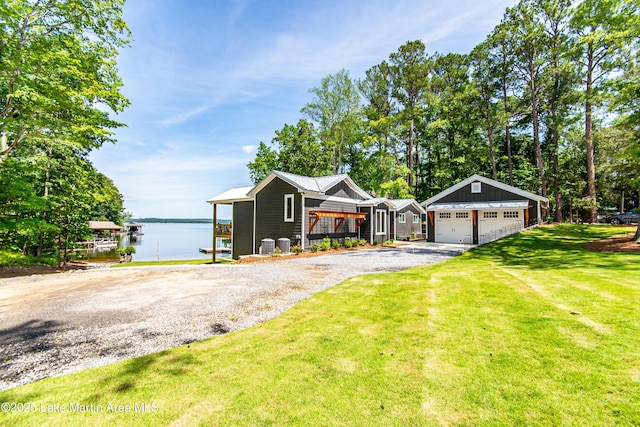 single story home with a garage, a water view, and a front lawn