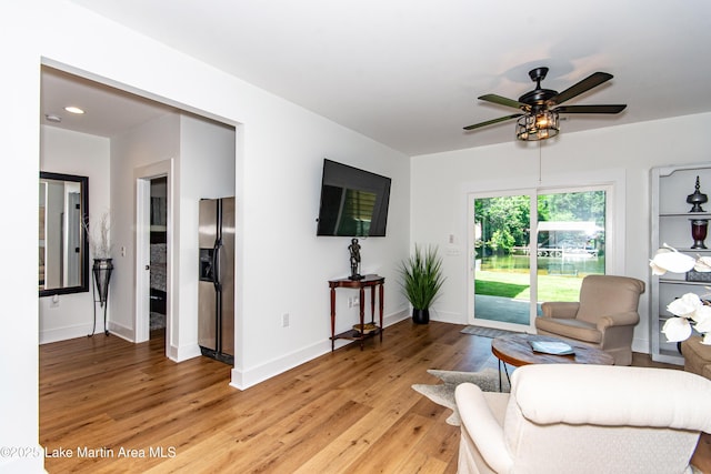 living room with ceiling fan and light hardwood / wood-style floors