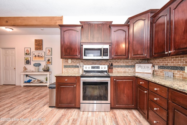 93 Restful Cv, Dadeville, AL 36853 - kitchen featuring appliances with stainless steel finishes, tasteful backsplash, light stone countertops, and light wood finished floors