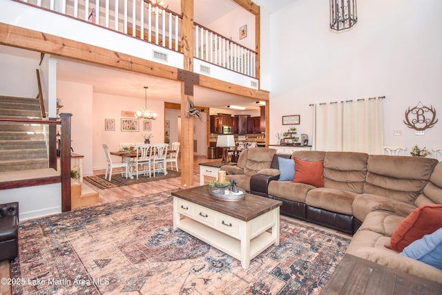 93 Restful Cv, Dadeville, AL 36853 - living room featuring a chandelier, stairway, a towering ceiling, and wood finished floors