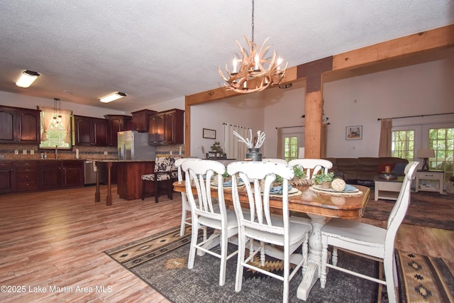 93 Restful Cv, Dadeville, AL 36853 - dining area featuring a chandelier, a textured ceiling, and light wood finished floors