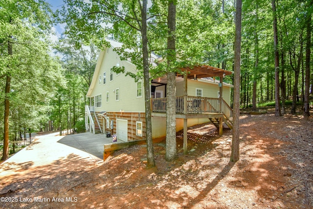 93 Restful Cv, Dadeville, AL 36853 - rear view of property with stairway, a wooden deck, and an attached garage