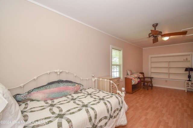 bedroom featuring ceiling fan, ornamental molding, and light wood-type flooring