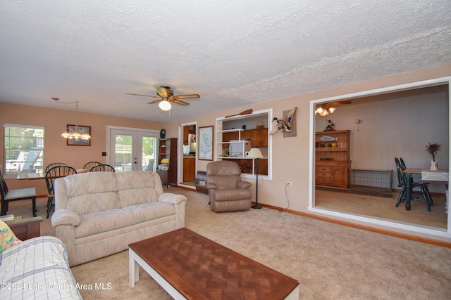 living room with ceiling fan, french doors, light carpet, and a textured ceiling