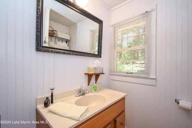 bathroom with vanity, crown molding, and wooden walls