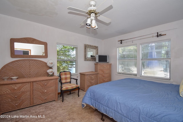 bedroom featuring light colored carpet, multiple windows, and ceiling fan