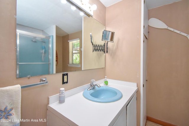 bathroom featuring vanity and a shower with door