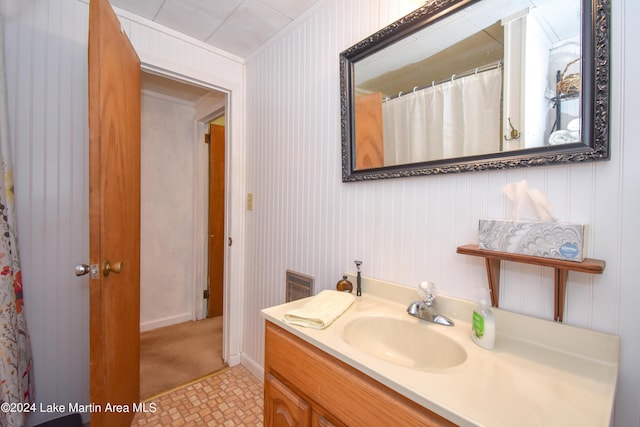 bathroom with tile patterned floors, vanity, and wood walls