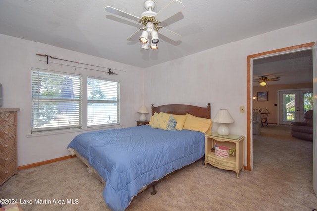 carpeted bedroom featuring multiple windows, ceiling fan, and french doors