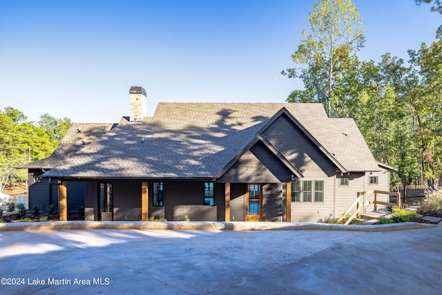 view of front of home featuring roof with shingles and a porch