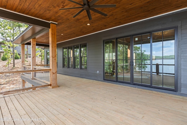 wooden terrace featuring a ceiling fan and a water view