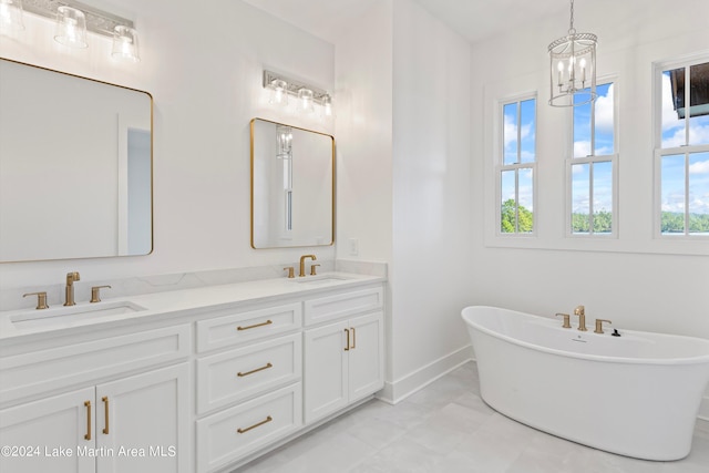 bathroom featuring vanity, a bathing tub, and a notable chandelier