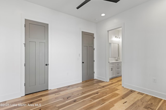 unfurnished bedroom featuring recessed lighting, connected bathroom, baseboards, and light wood finished floors