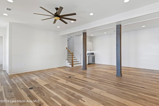 basement featuring ceiling fan and light hardwood / wood-style flooring