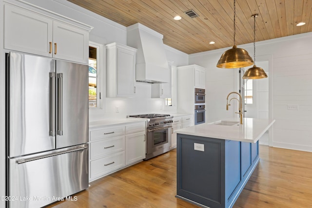 kitchen with light hardwood / wood-style floors, white cabinets, pendant lighting, and premium appliances