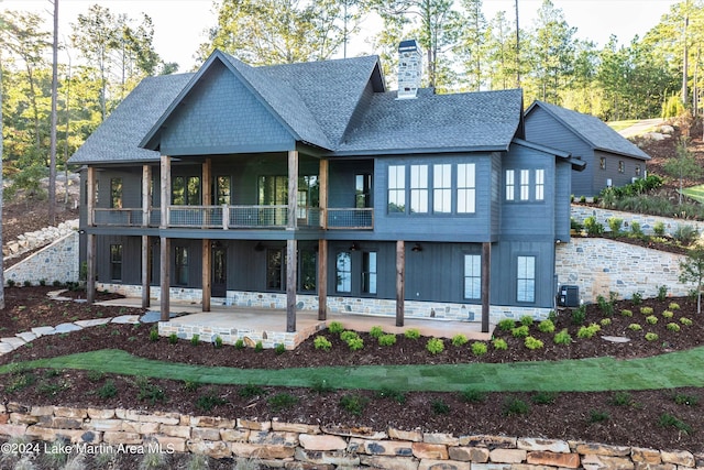 view of front of home with central air condition unit, a balcony, and a patio