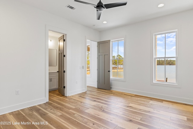 unfurnished bedroom featuring visible vents, baseboards, light wood finished floors, ensuite bath, and recessed lighting