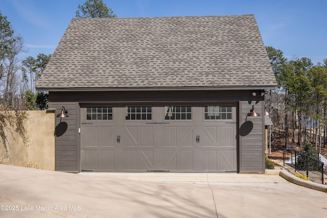 detached garage featuring fence