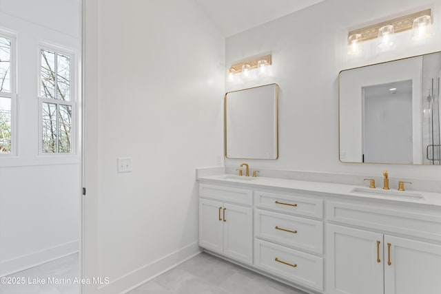 bathroom with a sink, baseboards, and double vanity