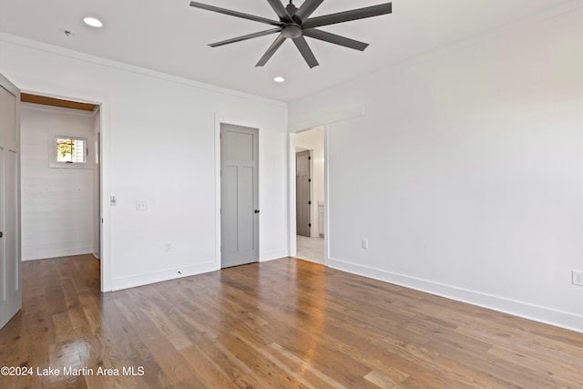 unfurnished bedroom featuring ceiling fan, crown molding, and hardwood / wood-style flooring