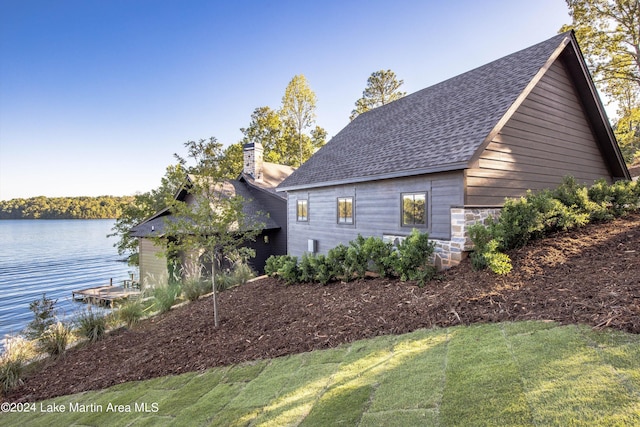 view of side of home with a lawn and a water view