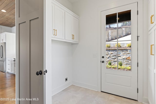 washroom featuring cabinet space, baseboards, and hookup for an electric dryer