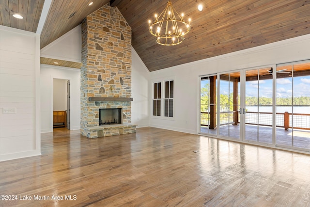 unfurnished living room featuring hardwood / wood-style floors, high vaulted ceiling, wooden ceiling, and a stone fireplace