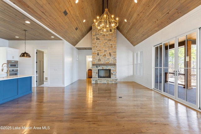 unfurnished living room with visible vents, wooden ceiling, a fireplace, wood finished floors, and high vaulted ceiling