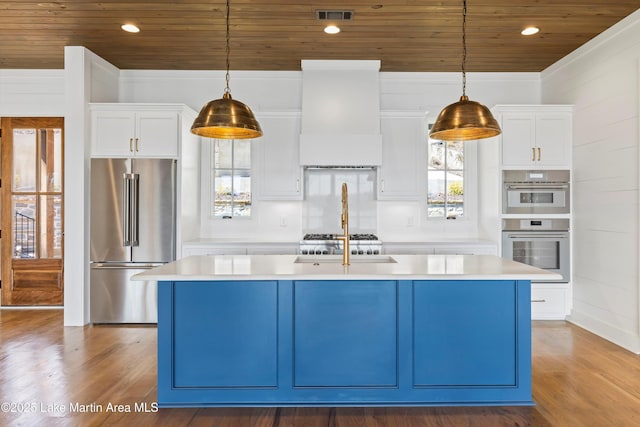 kitchen with premium range hood, visible vents, a kitchen island with sink, stainless steel appliances, and wooden ceiling