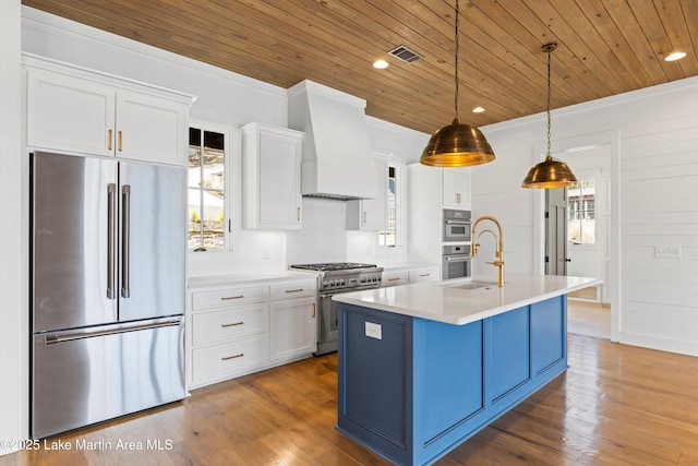 kitchen with a wealth of natural light, custom exhaust hood, high end appliances, and wooden ceiling