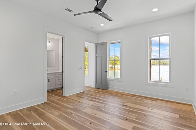 unfurnished bedroom featuring ensuite bathroom, ceiling fan, and light hardwood / wood-style floors