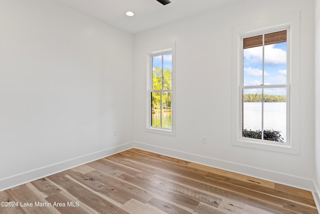 spare room with a water view and light hardwood / wood-style flooring