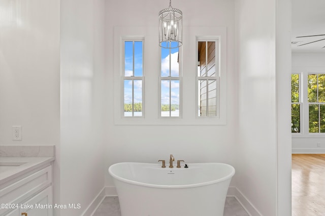 bathroom featuring a bathtub, wood-type flooring, vanity, and a chandelier