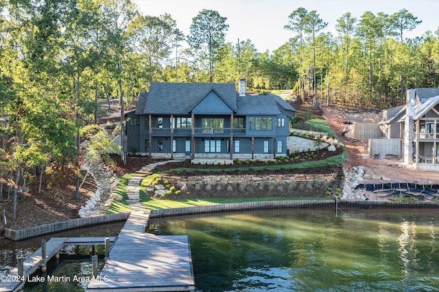 rear view of house featuring a water view and a balcony