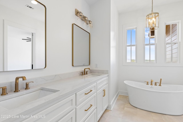 full bathroom featuring a sink, visible vents, a soaking tub, and double vanity