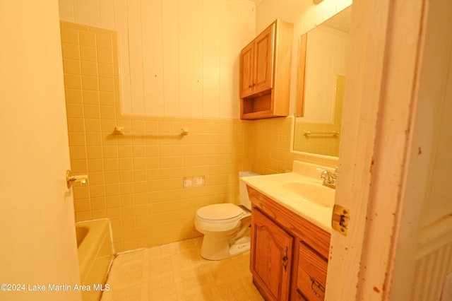 bathroom featuring vanity, toilet, a tub, and tile walls